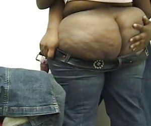 A beautiful black ass getting help putting her jeans on.